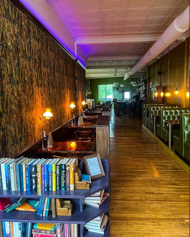 View down the bar past the bookshelves at night